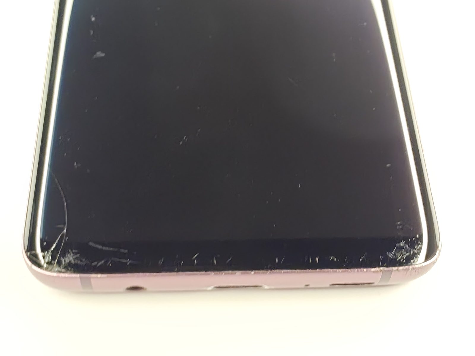 Samsung Galaxy S9+ screen crack and bottom edge chipping close-up